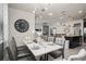 Elegant dining area featuring a sleek white table, modern chandelier, and open layout with kitchen view at 1607 Kona Ln, Davenport, FL 33897