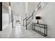 Bright foyer with white tile flooring and staircase with black accents at 1607 Kona Ln, Davenport, FL 33897