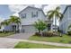 Charming home features two-car garage, paved driveway, and lush landscaping with palm trees at 1607 Kona Ln, Davenport, FL 33897