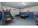 Large recreational game room offers activities with ping pong, basketball, and a pool table, all with great overhead lighting at 1607 Kona Ln, Davenport, FL 33897