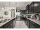 Modern kitchen featuring stainless steel appliances, granite countertops, and dark wood cabinetry at 1607 Kona Ln, Davenport, FL 33897