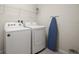 Functional laundry room equipped with washer, dryer, ironing board, and ample shelving for storage at 1607 Kona Ln, Davenport, FL 33897