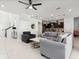 Open living room with grey sectional sofa and view into kitchen at 1607 Kona Ln, Davenport, FL 33897