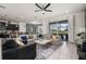 Open-concept living room featuring a ceiling fan, neutral furniture, and sliding glass doors to the backyard at 1607 Kona Ln, Davenport, FL 33897