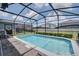 Relax in the spacious in-ground pool surrounded by a screened enclosure with ample space for outdoor lounging at 1607 Kona Ln, Davenport, FL 33897