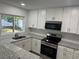Bright kitchen features granite countertops, stainless steel appliances, and modern white cabinets at 2009 S Osceola Ave, Orlando, FL 32806