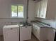 Bright laundry room, featuring washer, dryer, and updated cabinets at 2009 S Osceola Ave, Orlando, FL 32806