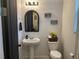 Charming half-bathroom with pedestal sink, decorative mirror, and modern fixtures at 2211 Bittle Way, St Cloud, FL 34769