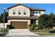 Inviting two-story home featuring a well-manicured lawn, brown accents, and an attached two-car garage at 2211 Bittle Way, St Cloud, FL 34769