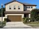 Inviting two-story home featuring a well-manicured lawn, brown accents, and an attached two-car garage at 2211 Bittle Way, St Cloud, FL 34769