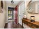 Bright and airy entryway with hardwood floors and a red front door at 241 Lake Thomas Dr, Winter Haven, FL 33880