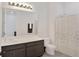 Bright bathroom with modern vanity, toilet, and shower with decorative curtain at 2587 Summer Star Way, Leesburg, FL 34748