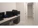 Open space with gray-tone desk and chair facing a hallway with light tile flooring at 2587 Summer Star Way, Leesburg, FL 34748
