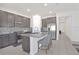 Eat-in kitchen with gray island, stainless appliances, tile backsplash, and tile flooring at 2587 Summer Star Way, Leesburg, FL 34748
