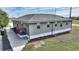 Grey house with red door and walkway, surrounded by landscaping at 3610 Old Berkley Rd, Auburndale, FL 33823