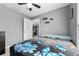 Cozy bedroom with grey walls, ceiling fan, and a large window provides natural light and a view of the backyard at 3618 Willow Lake Ct, St Cloud, FL 34769