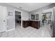 Cozy kitchen featuring tiled flooring, dark wood cabinets, and an open layout with views of the living and dining areas at 3618 Willow Lake Ct, St Cloud, FL 34769
