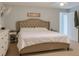 Serene bedroom featuring a tufted headboard, neutral colors, soft lighting, and a view of the entry door at 570 Bristol Cir, Kissimmee, FL 34758
