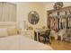 Bright bedroom features a vanity, round mirror, and a closet with neatly arranged clothes and shoes at 570 Bristol Cir, Kissimmee, FL 34758