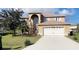 Charming, two-story home showcasing a well-maintained lawn, arched entryway, and attached two-car garage at 570 Bristol Cir, Kissimmee, FL 34758
