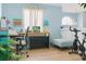 Well-lit home office featuring a desk, exercise bike, light blue walls, and modern decor at 570 Bristol Cir, Kissimmee, FL 34758