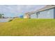 Wide backyard with lush green grass and view of the home's neutral exterior paint at 6144 Forest Ridge Way, Winter Haven, FL 33881