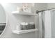Contemporary bathroom shelves hold towels and decorative items near a shower with a gray and white striped curtain at 6144 Forest Ridge Way, Winter Haven, FL 33881