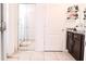 Bathroom featuring white tiled flooring, walk-in shower, dark cabinets and white vessel sink at 6144 Forest Ridge Way, Winter Haven, FL 33881