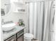 Stylish bathroom featuring a modern sink, granite countertop, decorative shelves, and a neutral-toned striped shower curtain at 6144 Forest Ridge Way, Winter Haven, FL 33881