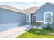 Charming home featuring a blue exterior, white-framed windows, and a walkway lined with white gravel at 6144 Forest Ridge Way, Winter Haven, FL 33881