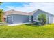 Modern single-story home featuring manicured lawn, gray exterior and clean landscaping at 6144 Forest Ridge Way, Winter Haven, FL 33881
