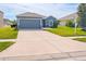 Well-maintained single-story home featuring a spacious driveway, lawn, and a gray exterior at 6144 Forest Ridge Way, Winter Haven, FL 33881