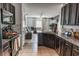 Open concept kitchen featuring granite countertops, dark cabinets, tile floors and view to the living room at 6144 Forest Ridge Way, Winter Haven, FL 33881