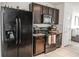 A kitchen with a stainless steel refrigerator, black oven, and dark cabinets at 6144 Forest Ridge Way, Winter Haven, FL 33881