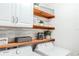 Laundry room with a washing machine, dryer, wooden shelves, and decorative accents at 6144 Forest Ridge Way, Winter Haven, FL 33881