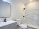 Modern bathroom with gray vanity, marble shower, and white toilet at 645 King St, Eustis, FL 32726