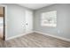 Bright bedroom with wood-look floors and an open door to the bathroom at 645 King St, Eustis, FL 32726