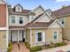 Attractive tan townhome with a brown roof, landscaping, and walkway at 7591 Sunny Dreams Ln, Kissimmee, FL 34747