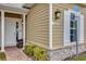 Townhome entrance with a white door, brick walkway, and lamp at 7591 Sunny Dreams Ln, Kissimmee, FL 34747
