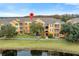 Exterior view of a two-story condo building with water features and landscaping at 8660 Buccilli Dr # 305, Orlando, FL 32829