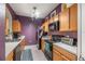 Galley kitchen with wood cabinets and purple walls at 8660 Buccilli Dr # 305, Orlando, FL 32829