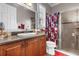 Bathroom featuring wood cabinetry, granite countertop, a glass-enclosed shower, and modern fixtures at 900 Windlass Ct, Kissimmee, FL 34746
