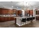 A spacious kitchen featuring dark wood cabinets, a large center island with seating, and decorative light fixtures at 900 Windlass Ct, Kissimmee, FL 34746