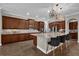 A spacious kitchen featuring dark wood cabinets, a large center island with seating, and decorative light fixtures at 900 Windlass Ct, Kissimmee, FL 34746