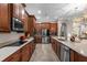 Kitchen featuring stainless steel appliances, dark wood cabinets, tile floors, and a large granite countertop at 900 Windlass Ct, Kissimmee, FL 34746