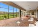 Covered patio with brick flooring, white chairs, dining table, and a view of nature at 900 Windlass Ct, Kissimmee, FL 34746