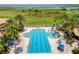 A luxurious community pool area featuring palm trees, lounge chairs, and beautiful lake views at 900 Windlass Ct, Kissimmee, FL 34746