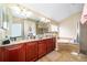Double vanity bathroom with granite countertop and large mirror at 11322 Bronson Rd, Clermont, FL 34711