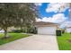 One-story home with a white garage door and driveway at 11322 Bronson Rd, Clermont, FL 34711