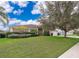 House with green lawn, landscaping, and a large tree at 11322 Bronson Rd, Clermont, FL 34711